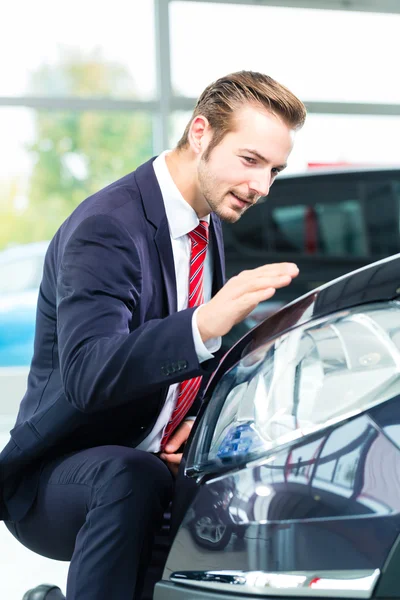 Auto revendedor em concessionária de automóveis — Fotografia de Stock