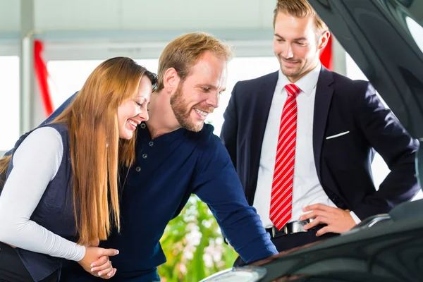 Junges Paar und Verkäufer mit Auto — Stockfoto