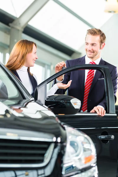 Woman and seller  in car dealership — Stock Photo, Image
