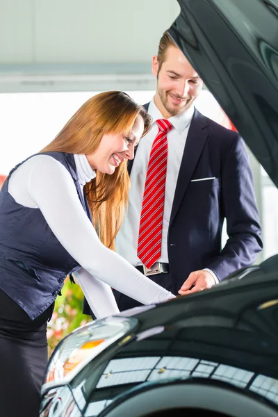 Junge Frau und Verkäufer mit Auto — Stockfoto