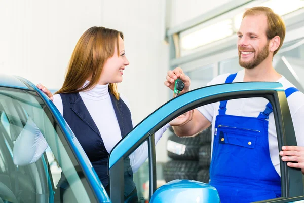 Cliente e carro mecânico na oficina de automóveis — Fotografia de Stock