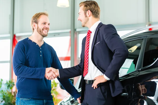 Joven hombre y vendedor con auto — Foto de Stock