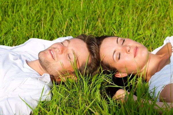 Pareja feliz acostada en un prado —  Fotos de Stock