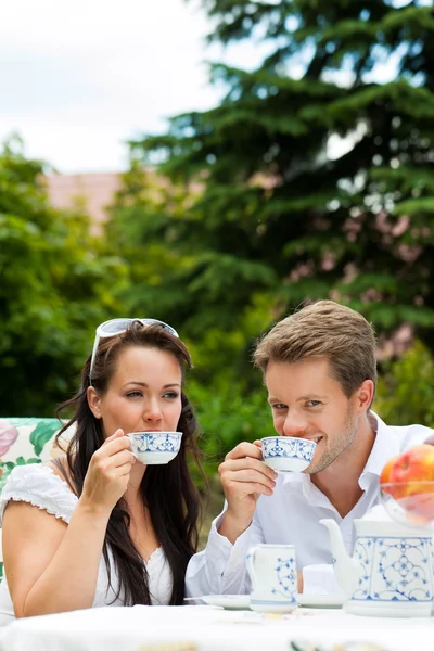 Et par drinker kaffe i hagen deres. – stockfoto