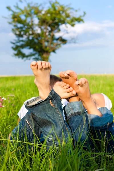 Casal feliz deitado em um prado — Fotografia de Stock