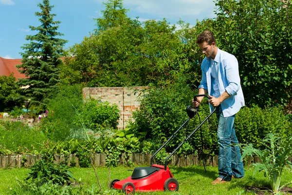 Man is mowing the lawn in summer — Stock Photo, Image