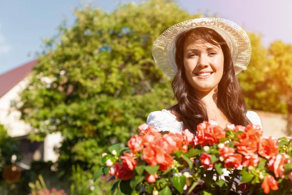 Kvinna i sommarträdgården med blommor — Stockfoto