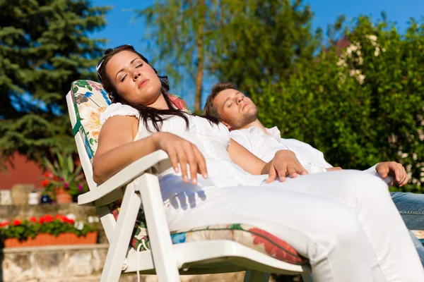 Paar ruht sich im Sommer im Liegestuhl aus — Stockfoto