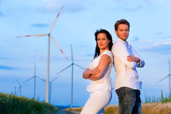 Powerful couple in front of windmill — Stock Photo, Image