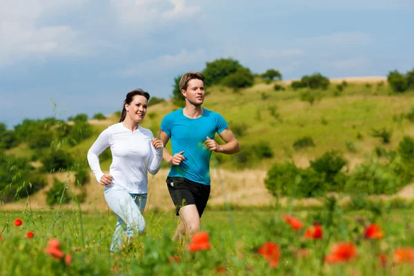 Giovane coppia sportiva è jogging al di fuori — Foto Stock