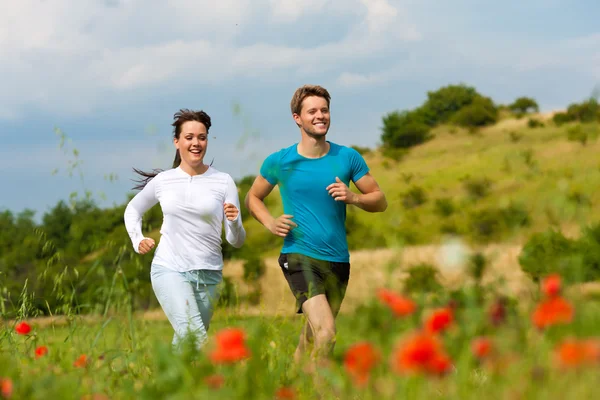 Ung sportig par jogging utanför — Stockfoto