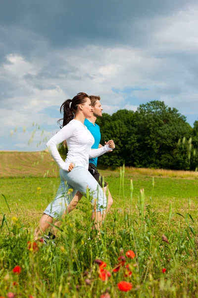 Giovane coppia sportiva è jogging al di fuori — Foto Stock