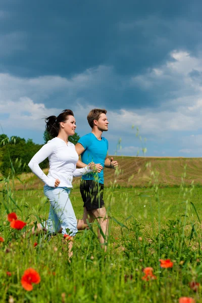 Joven pareja deportiva está corriendo fuera —  Fotos de Stock