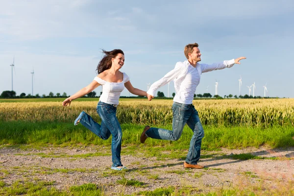 Casal feliz correndo em uma estrada de terra — Fotografia de Stock