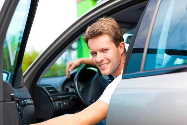 Mannen i bilen vid bensinstation — Stockfoto