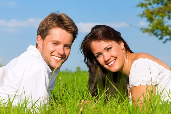 Pareja feliz acostada en un prado —  Fotos de Stock