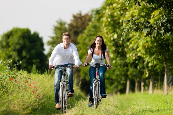 Man and woman cycling in summer Stock Photo