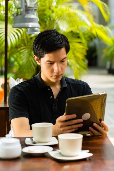 Ασιατική άνθρωπο σε καφέ με έναν υπολογιστή tablet — Φωτογραφία Αρχείου