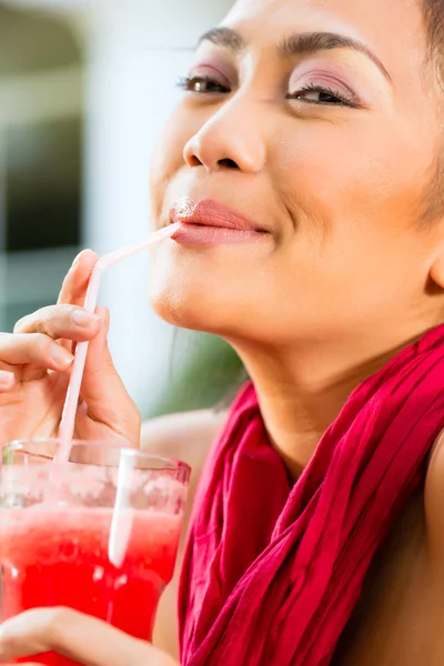 Asian woman in restaurant drinking — Stock Photo, Image