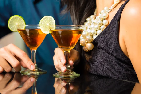 Man and woman at bar with cocktails — Stock Photo, Image