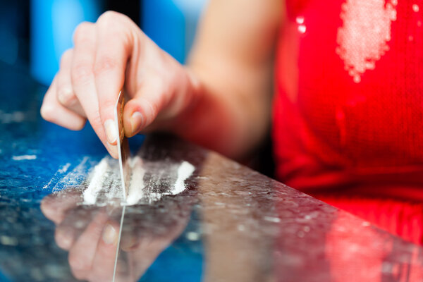 Young woman snorting cocaine