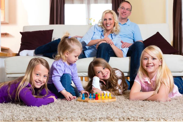 Família jogando jogo de tabuleiro em casa — Fotografia de Stock