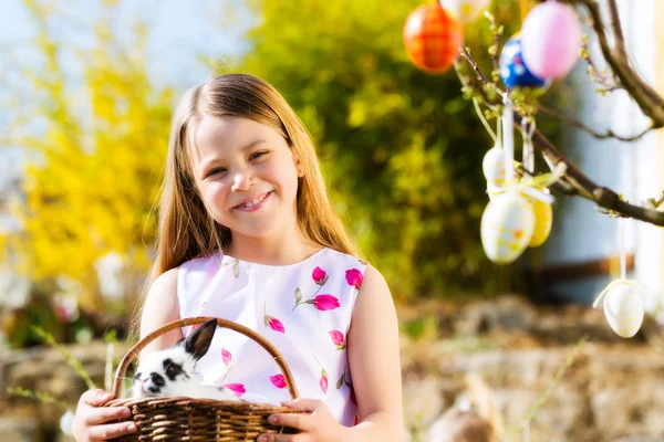 Enfant à la chasse aux œufs de Pâques avec lapin — Photo