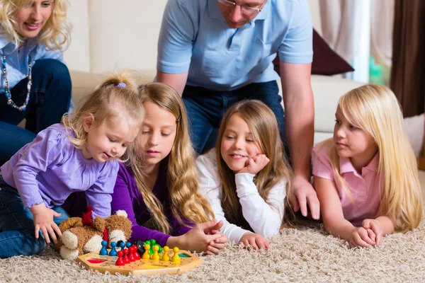 Família jogando jogo de tabuleiro em casa — Fotografia de Stock