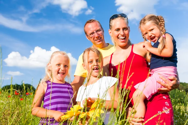 Family in grass in summer — Stock Photo, Image