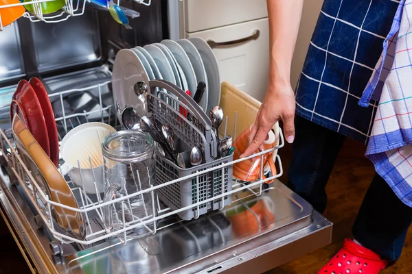 Ama de casa está lavando los platos con lavavajillas — Foto de Stock