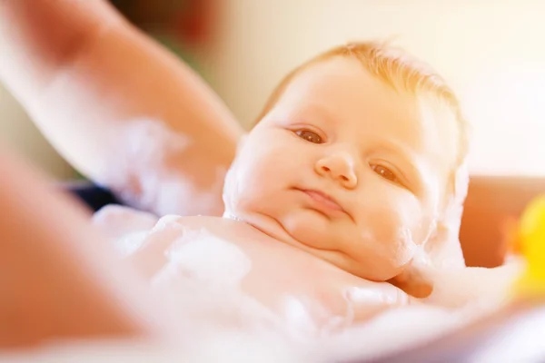 Mother is bathing her baby in bathtub — Stock Photo, Image