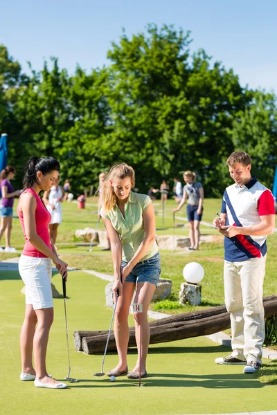 Menschen spielen Minigolf im Freien — Stockfoto