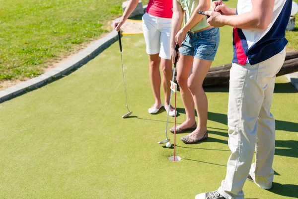 Mensen spelen miniatuur golf buitenshuis — Stockfoto
