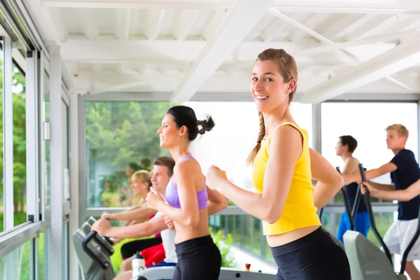 Mensen in sport sportschool op loopband lopen — Stockfoto