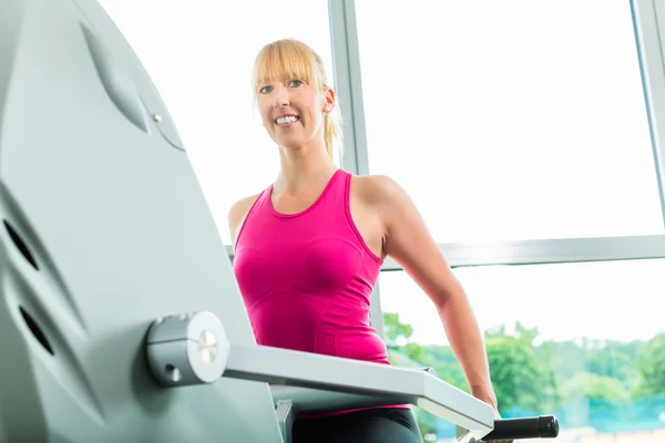 Mujer en deporte gimnasio en stepper — Foto de Stock