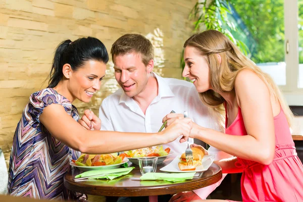 Мужчины и женщины едят свежий салат — стоковое фото