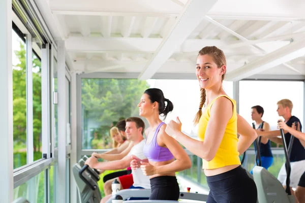 Mensen in sport sportschool op loopband lopen — Stockfoto