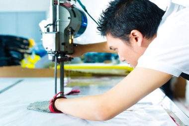 Çin fabrikasında makinasıyla işçi