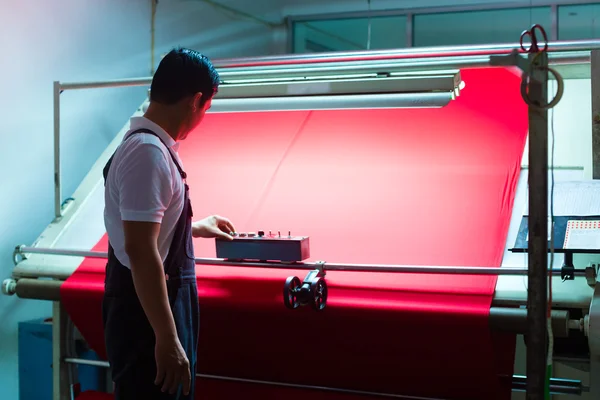 Азиатский рабочий контролирует ткани — стоковое фото