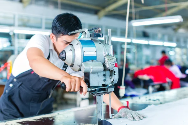 Trabalhador asiático usando uma máquina em uma fábrica — Fotografia de Stock