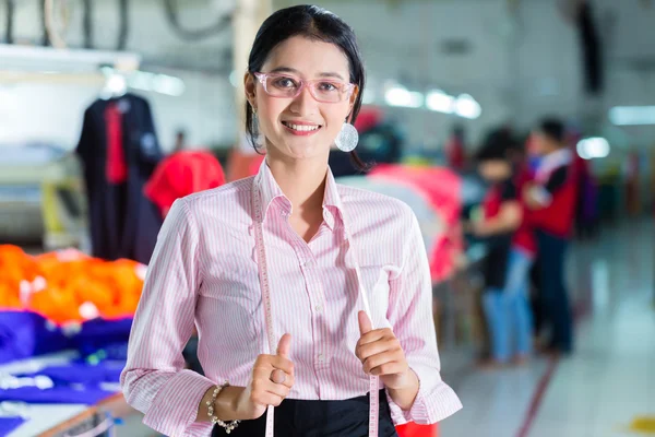 Asiática costureira em uma fábrica têxtil — Fotografia de Stock