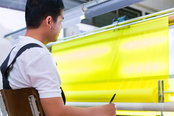 Asiatico lavoratore controlli tessuti — Foto Stock