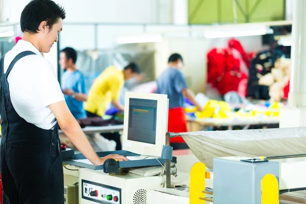 Trabajador en un máquina en asiático fábrica — Foto de Stock