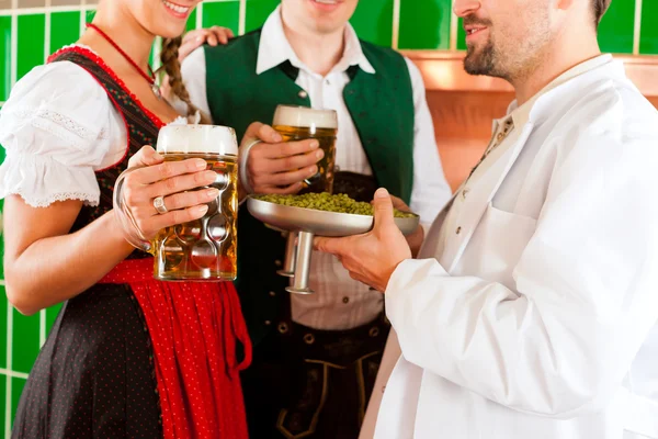 Casal com cerveja e seu cervejeiro na cervejaria — Fotografia de Stock