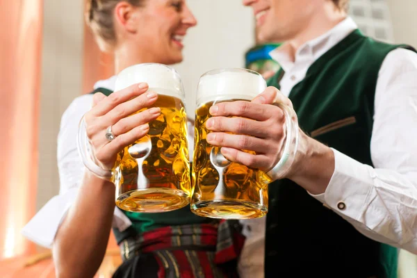 Uomo e donna con bicchiere di birra in birreria — Foto Stock