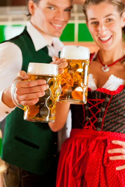 Uomo e donna con bicchiere di birra in birreria — Foto Stock