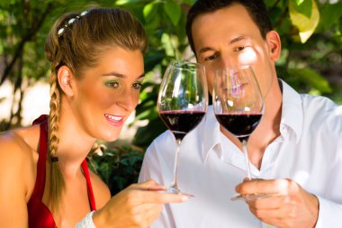 Üzüm bağında şarap içen kadın ve erkek