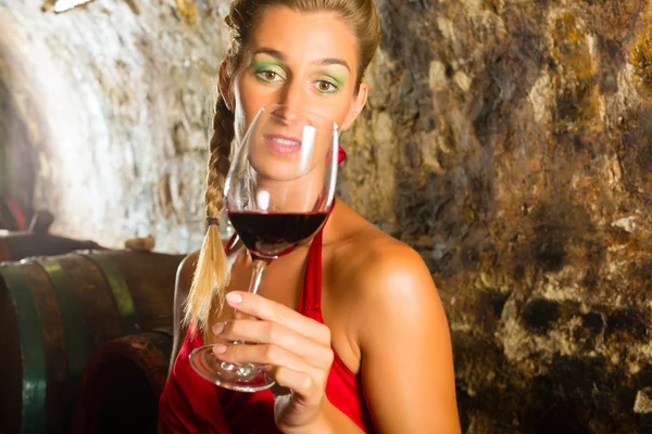 Woman with glass of wine looking skeptically — Stock Photo, Image