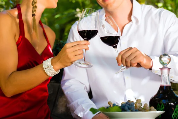 Frau und Mann im Weinberg trinken Wein — Stockfoto