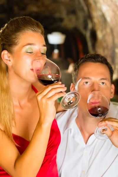 Homme et femme tendant le vin dans la cave — Photo